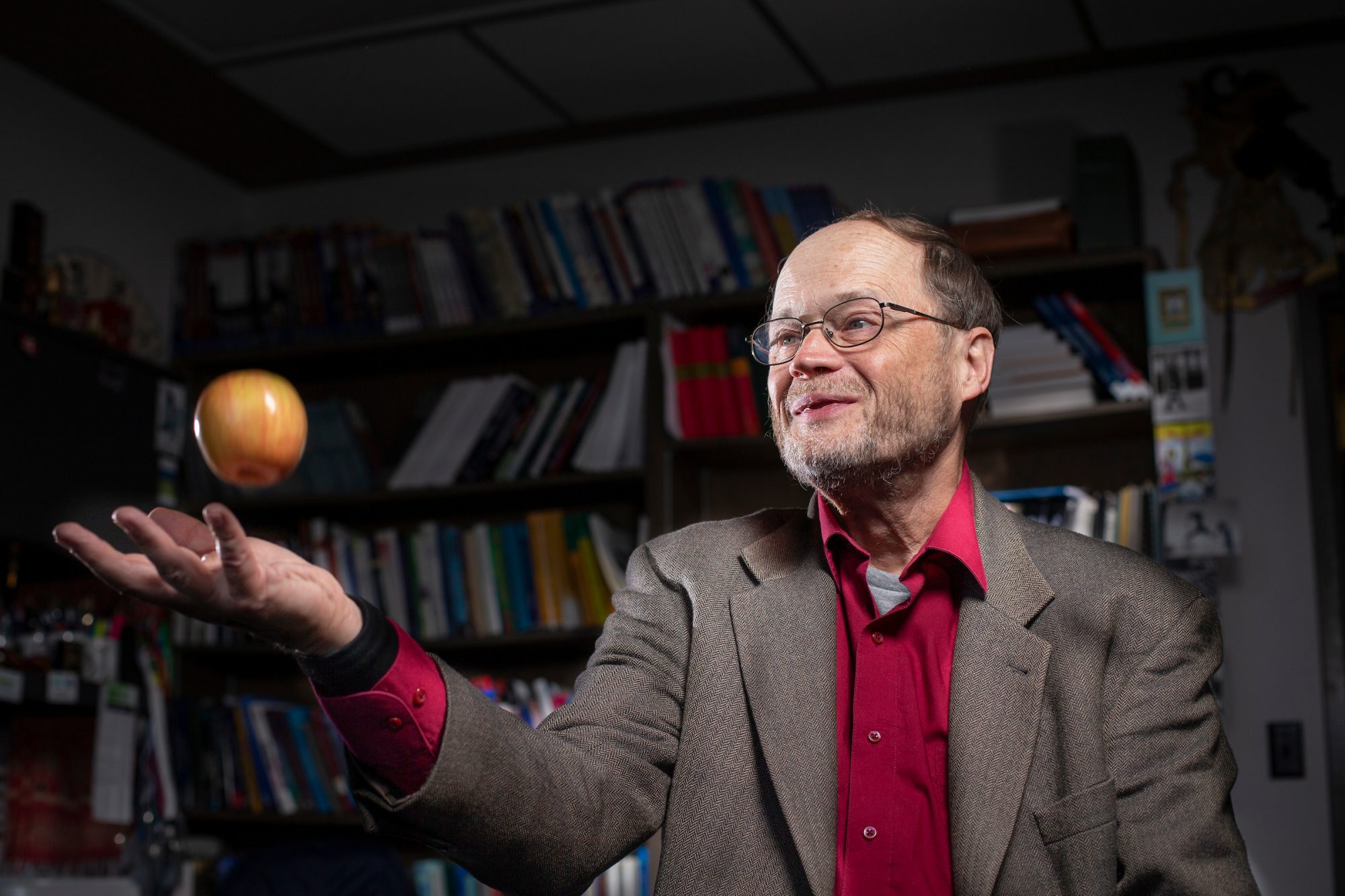 Mack Shelley tossing an apple into the air.