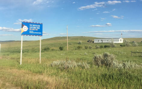 Photo of sign marking Northern Cheyenne reservation, in grassy area.