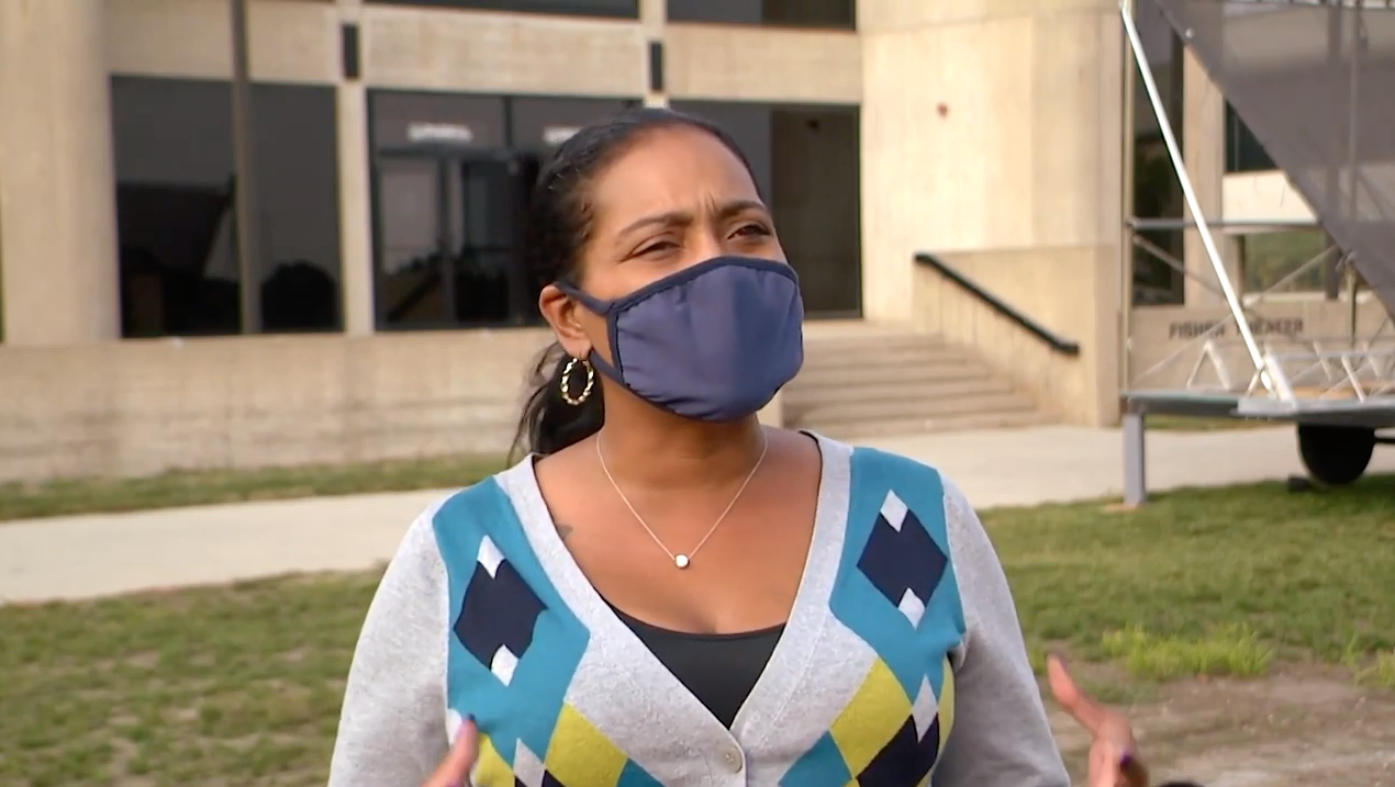 Artist in residence Tiffany Johnson standing in front of building with mask on