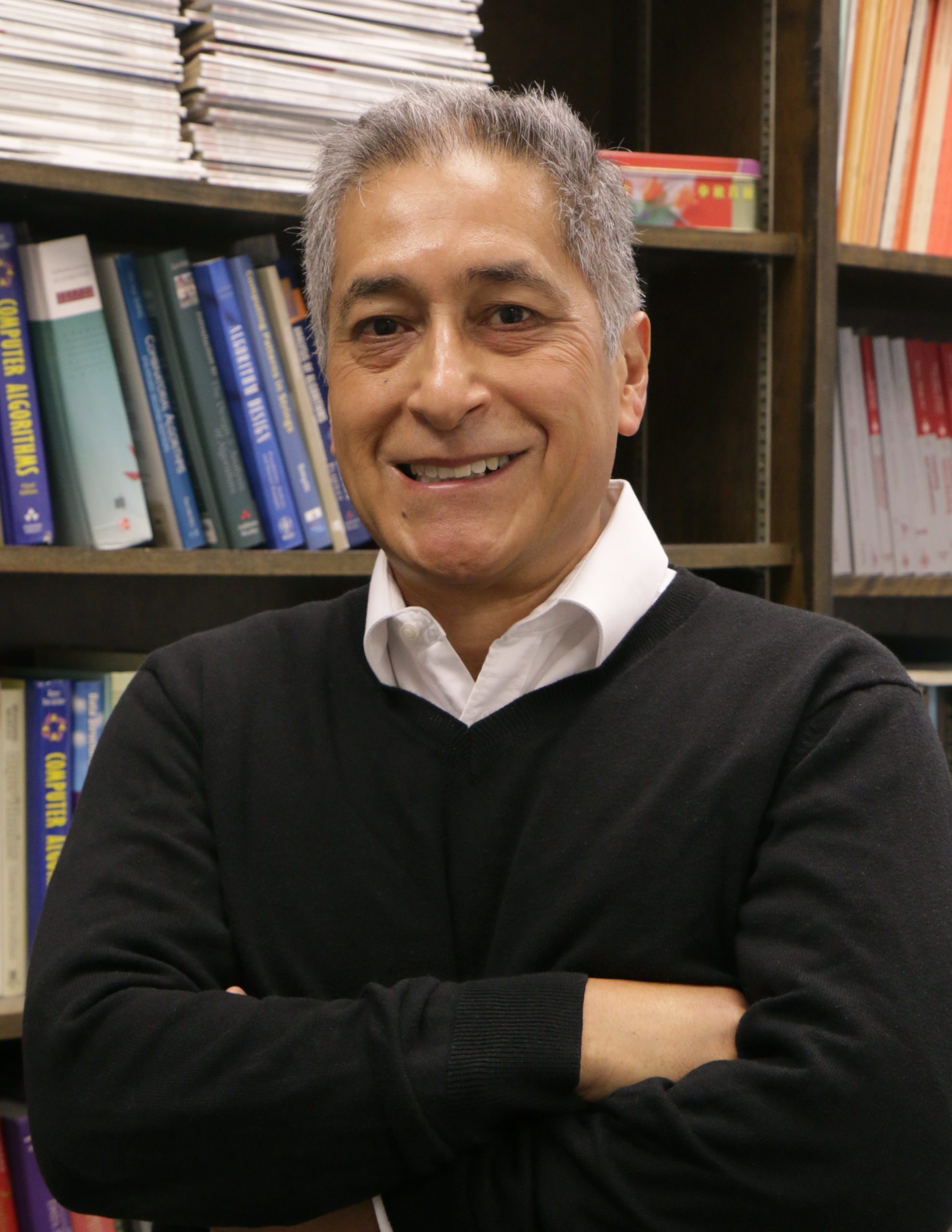 David Fernandez-Baca poses in front of bookshelf