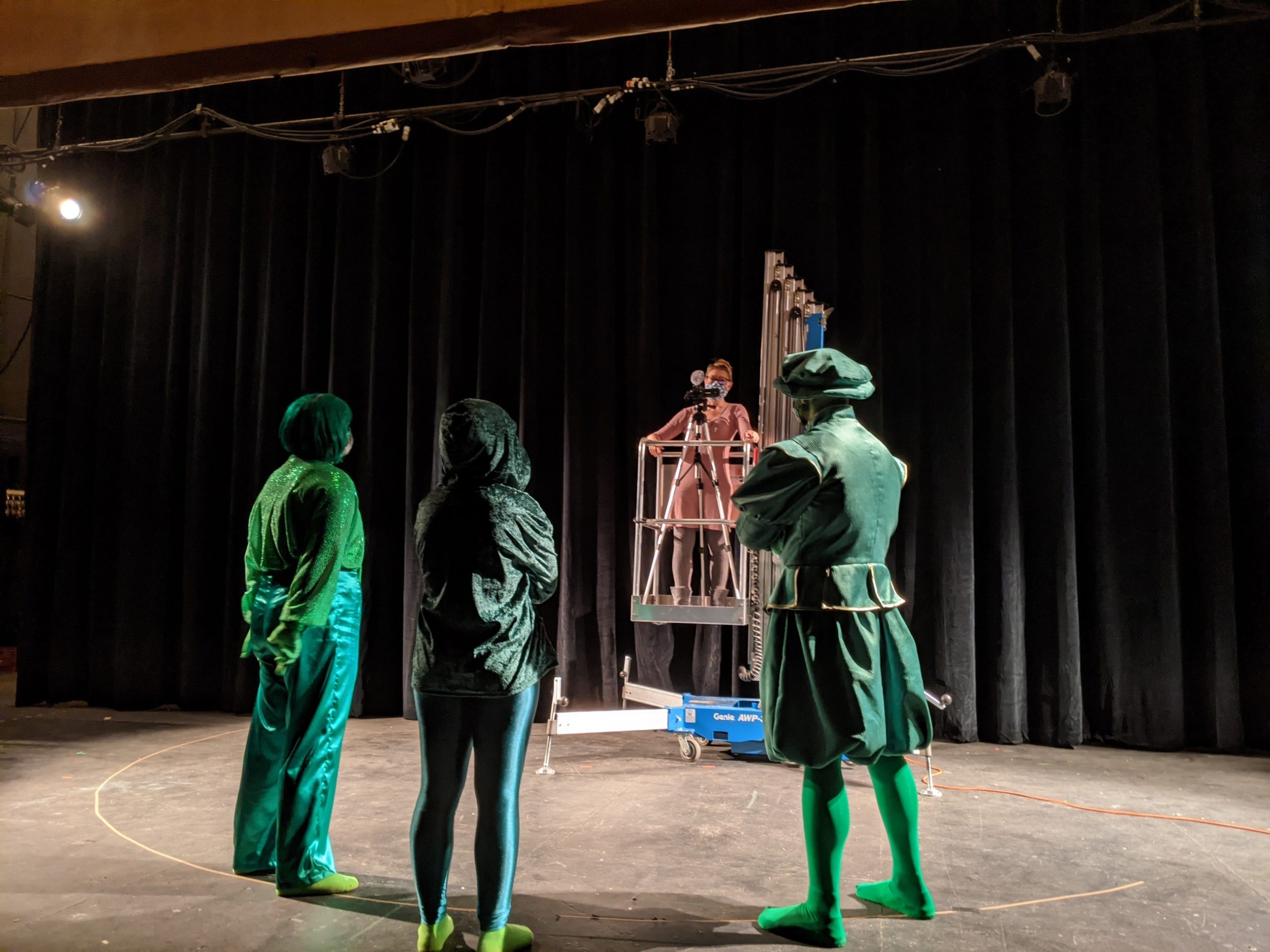 Three actors dressed in green on stage