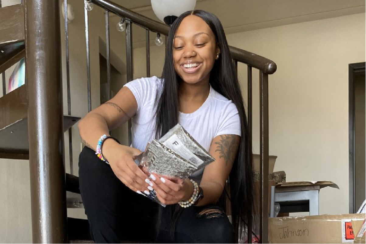 Student on stairs holding a package