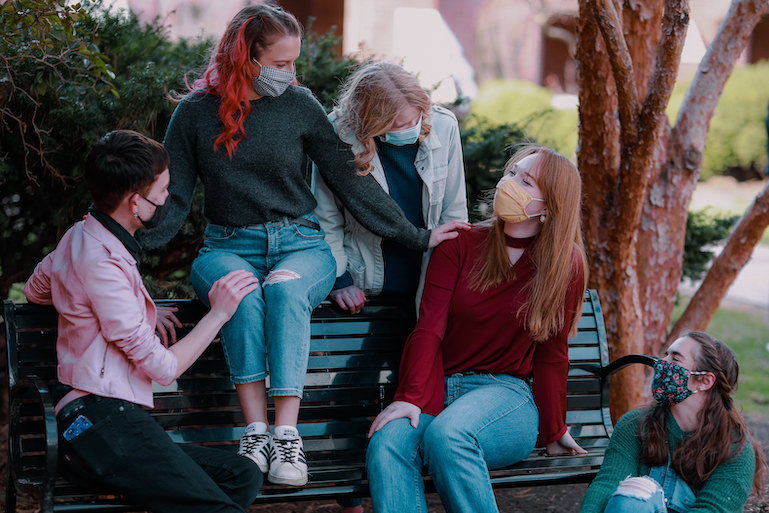 Students posing on a bench