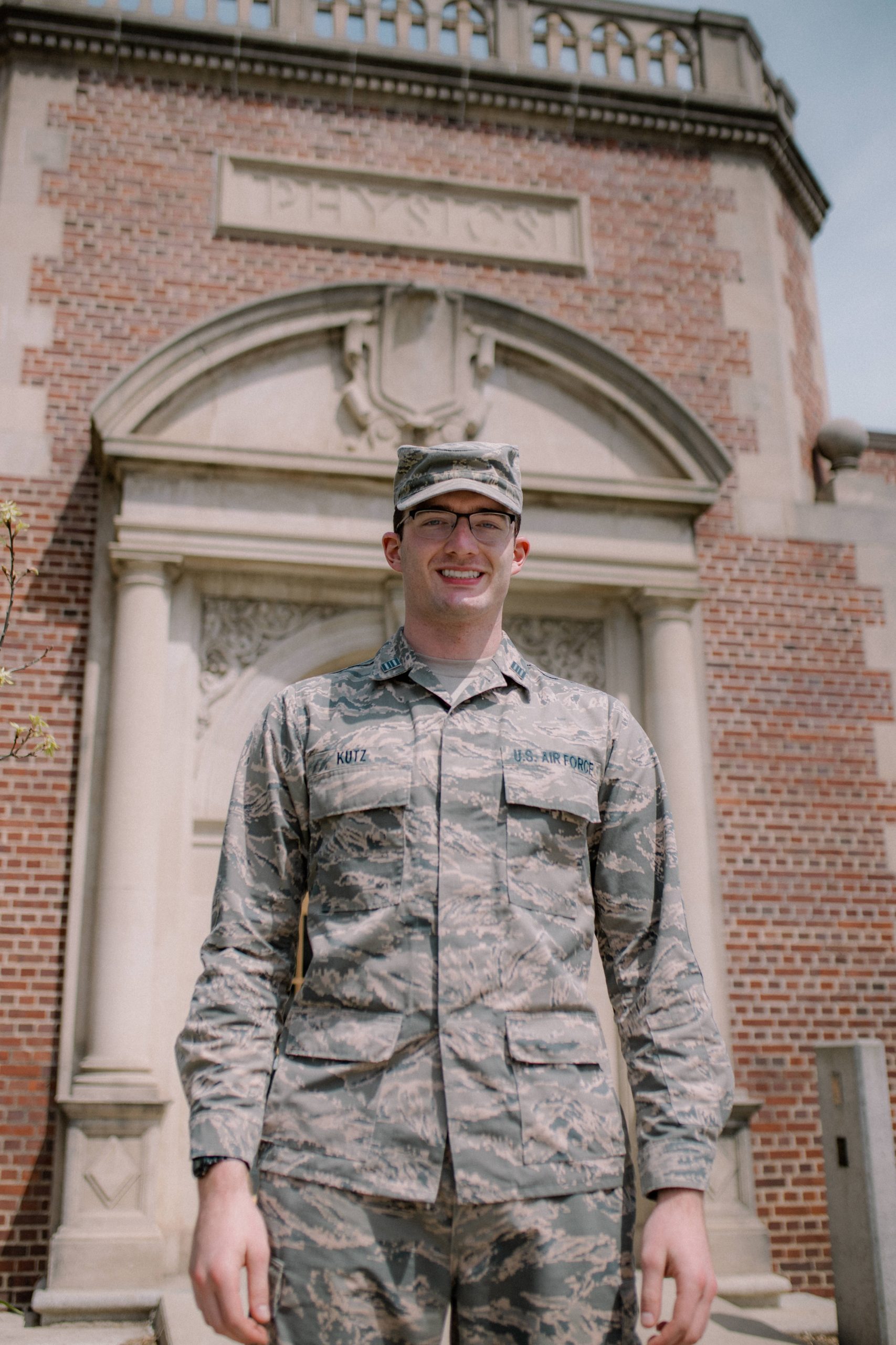 Graduating senior Noah Kutz stands in front of the Physics Building