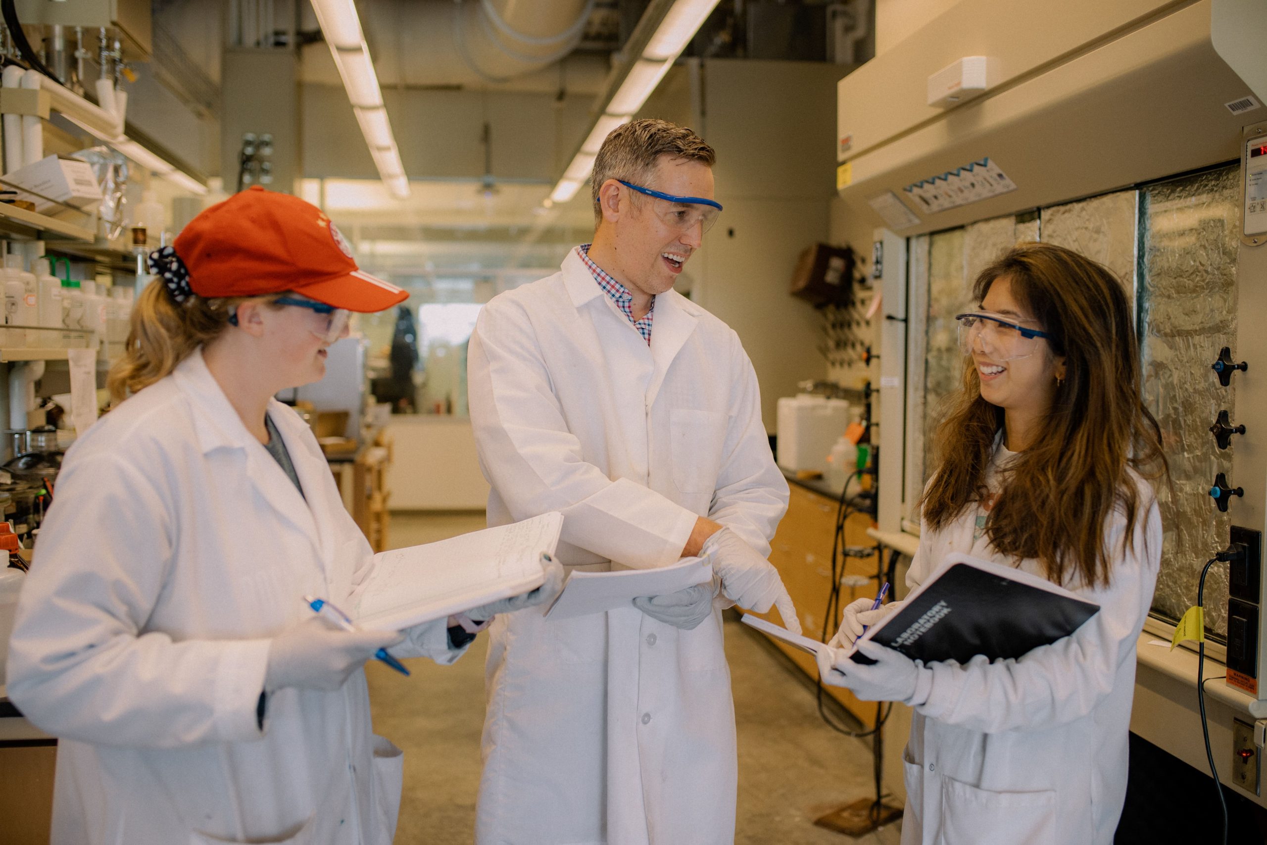 Arthur Winter, professor of chemistry, discusses research in his lab with two female graduate students