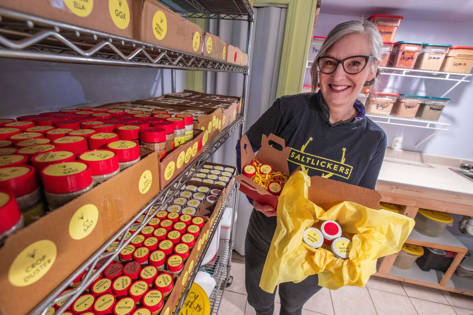 Jennifer Knox stands next to shelves filled with her seasoning blends