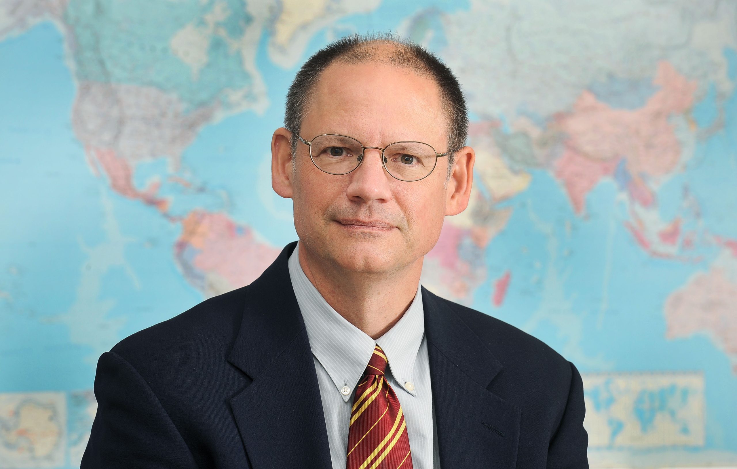 Peter Orazem, University Professor in Economics in front of a world map