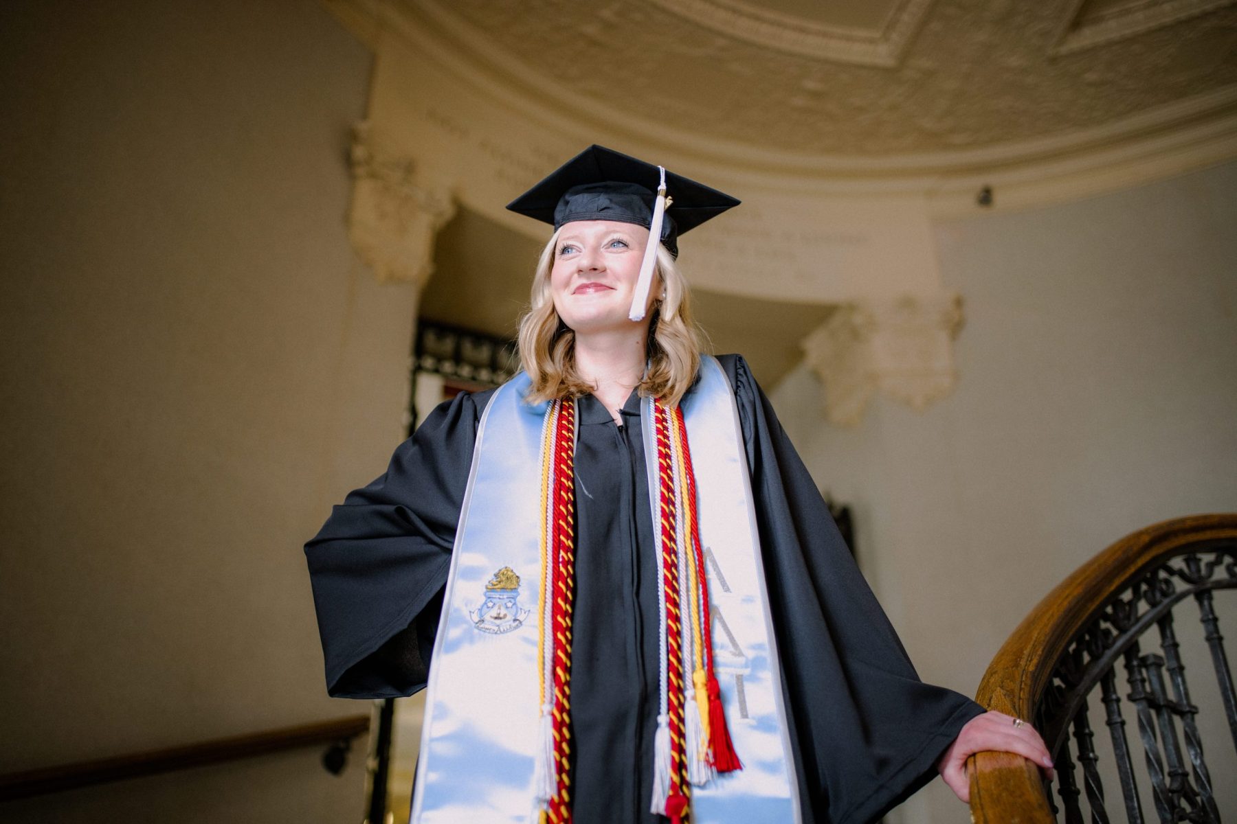 Graduate in cap and gown on stairway