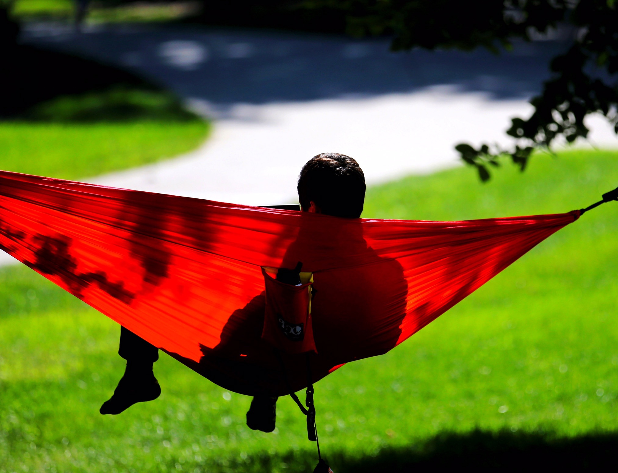 Photo of a student lying in a hammock on campus