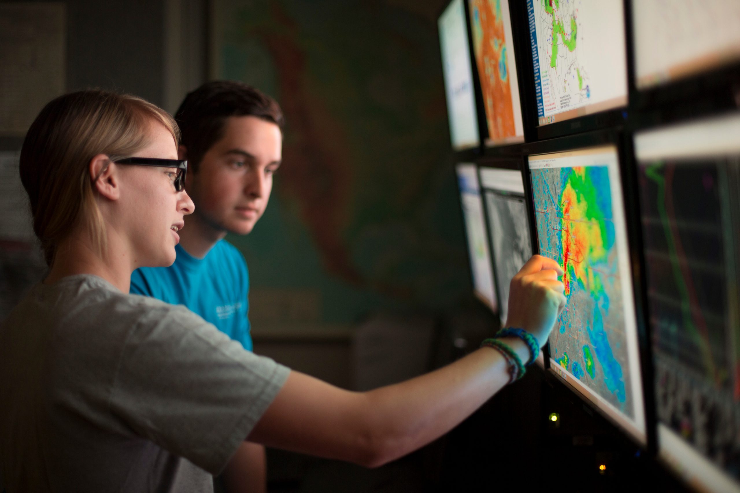 Meteorology faculty and students in front of screens showing radar