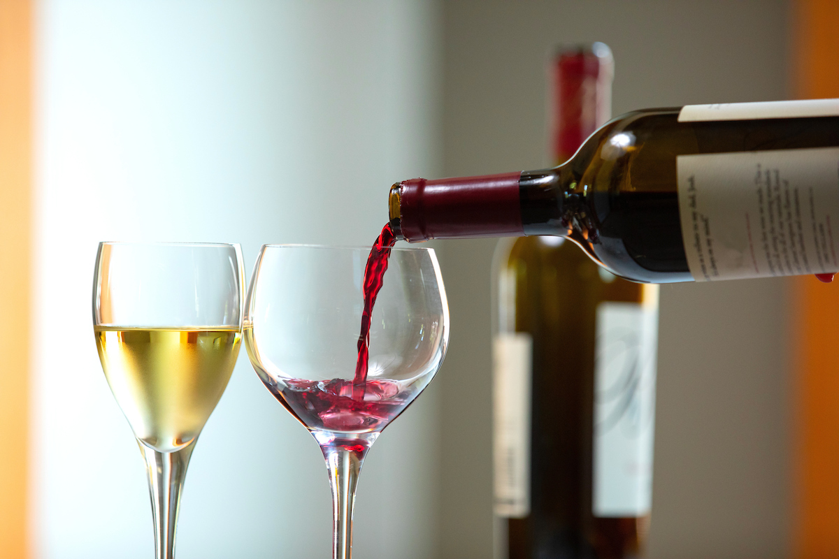 wine glasses filled with wine and wine bottles