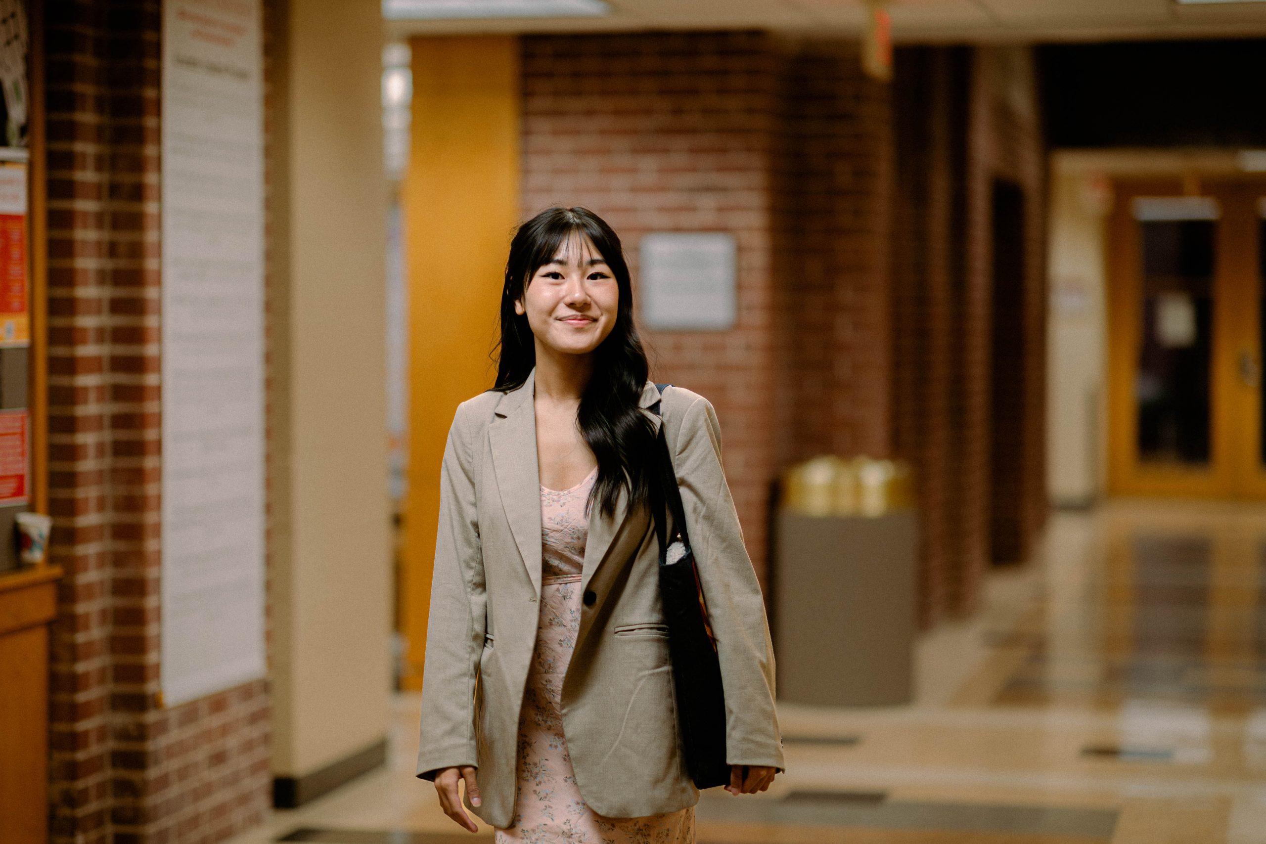 Student smiles walking in hallway