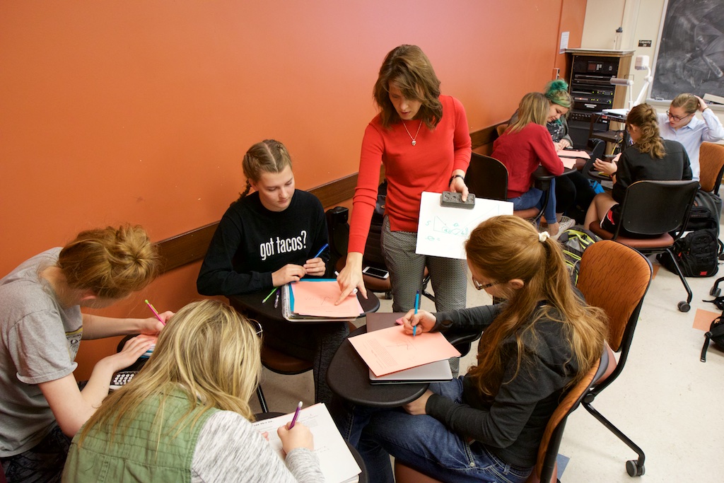 Heather Bolles helps students doing group work in a calculus class.