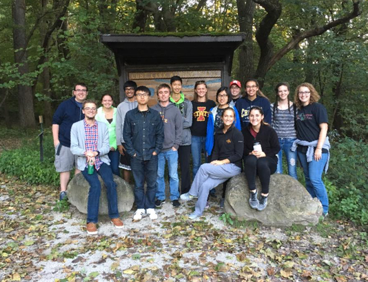 Students in the Mathematics and Statistics Learning Community pose at a park in front of the woods.