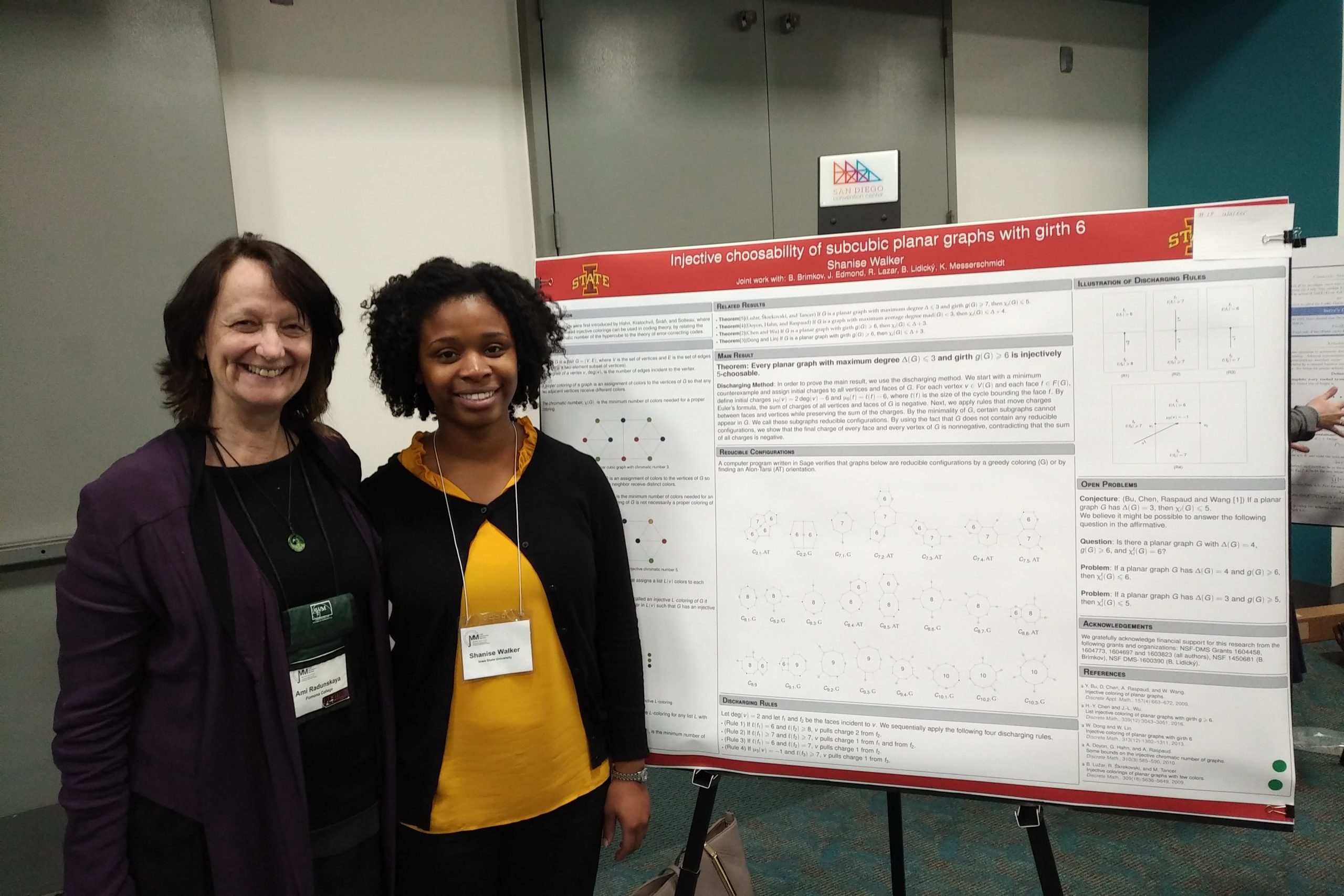 Two women stand in front of a research poster.