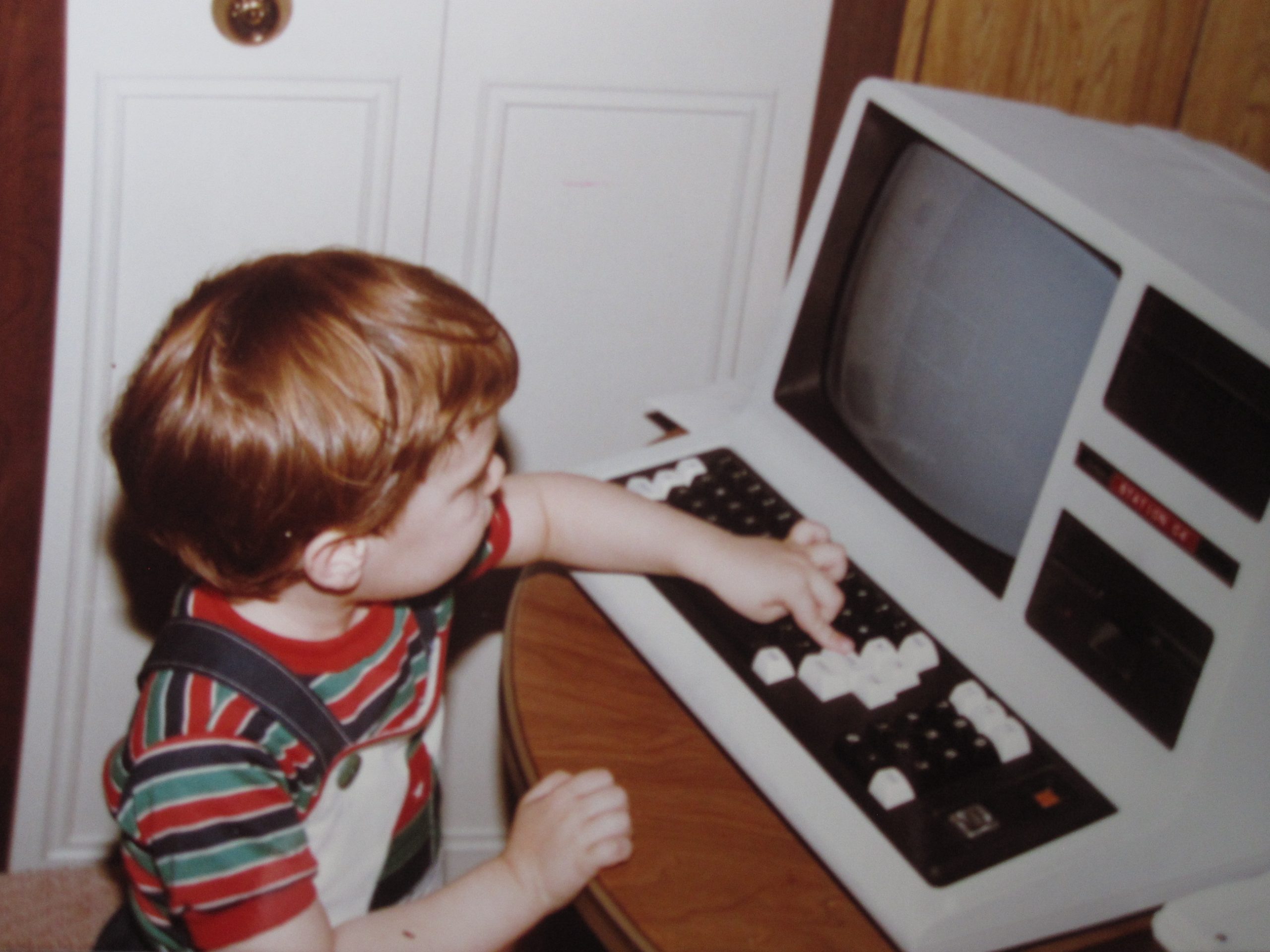 A boy looking at an old computer.