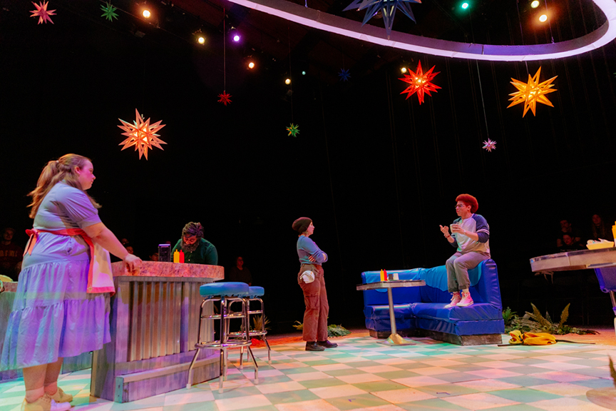 Actors on stage in a diner setting