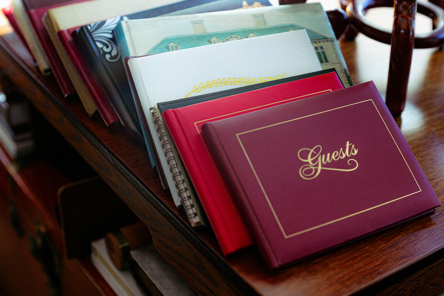 Pile of guest books displayed on a wooden table.