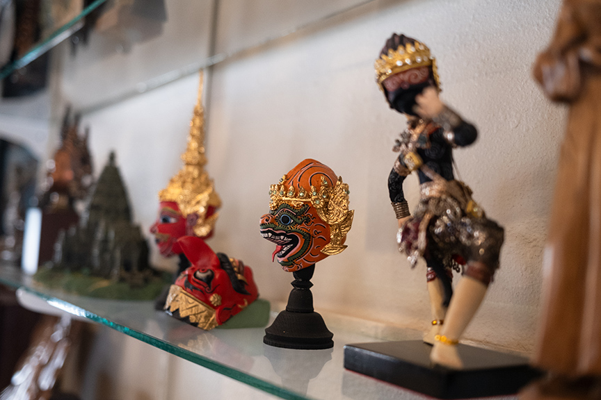 Figurines displayed on a glass shelf.