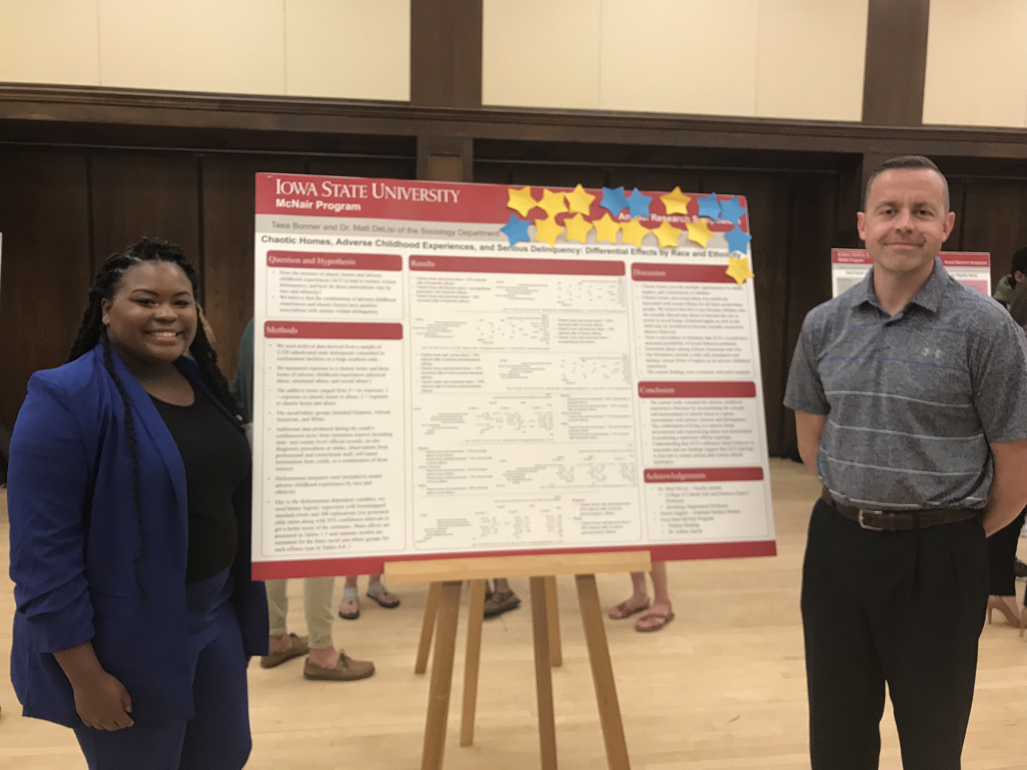 Young black woman and white man with academic research poster