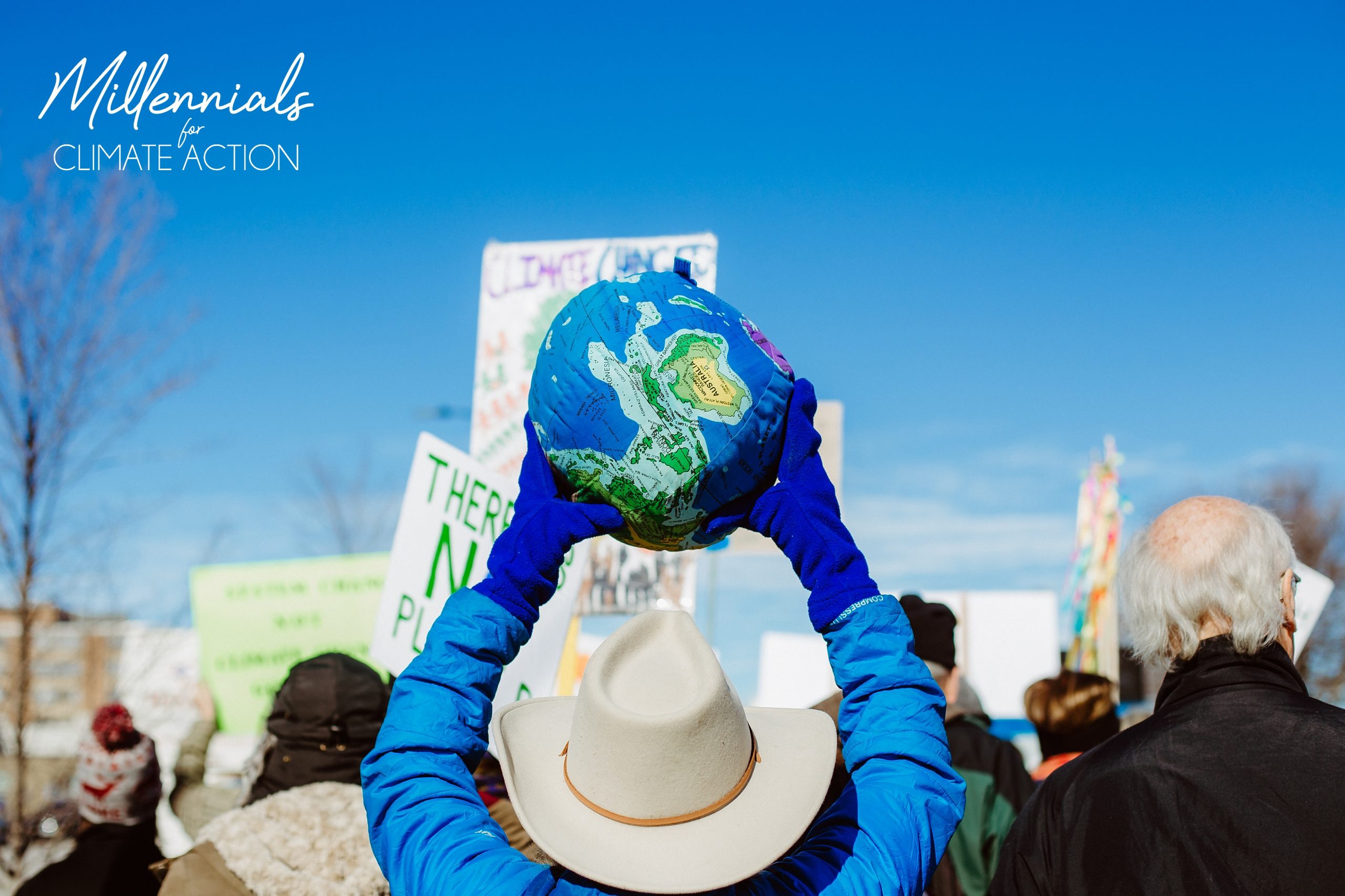 a person holding up a stuffed globe at a protest